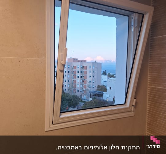 חלון אלומיניום פתוח עם מסגרת לבנה